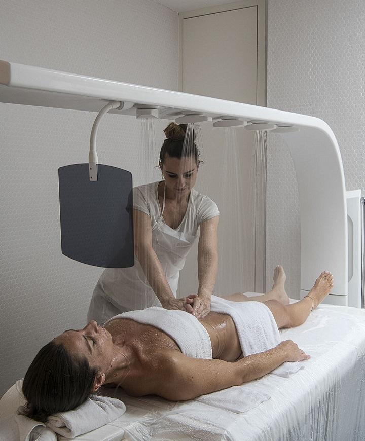 Massaggio rilassante sotto doccia a pioggia, atmosfera di benessere e serenità.